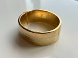 a close up of a gold ring on a white surface