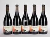 quatre bouteilles de vin sont alignées sur une surface blanche