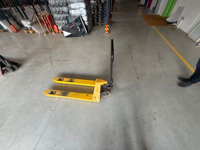 a man standing next to a forklift in a warehouse