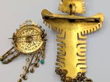 two pieces of jewelry that are sitting on a table