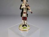 un gros plan sur une figurine représentant un homme jouant du violon