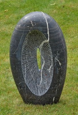 une sculpture en pierre noire percée d'un trou au milieu