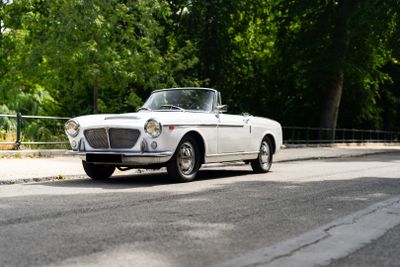 a white car that is driving down the street