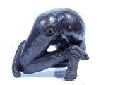 a statue of an elephant sitting on a white surface