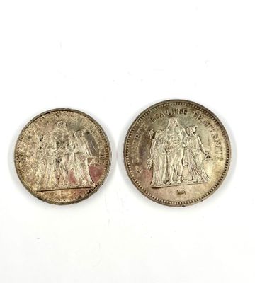 two silver coins, one of which is a woman and one of which is a man