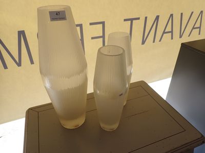 deux vases posés sur une table devant un panneau