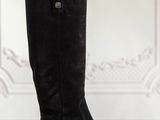 a pair of black boots sitting on top of a wooden table