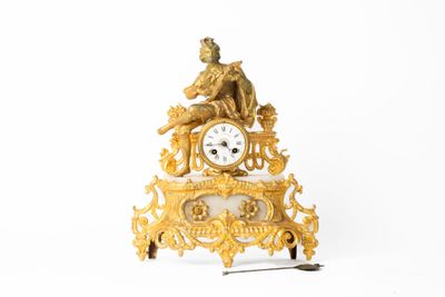 une horloge en or posée sur une table blanche