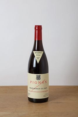 la bouteille de vin rouge est posée sur une table en bois