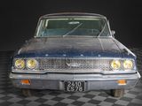 a old car that is sitting on a checkered floor