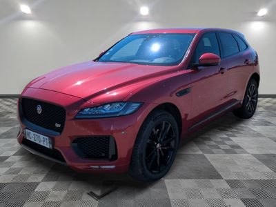 a red jaguar suv parked in a showroom