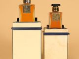 two bottles of perfume sitting on top of each other on display