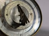 a close up of a compass on a table