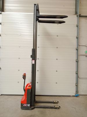 un chariot élévateur garé dans un garage dont la porte est ouverte