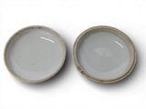 pair of white and gray bowls on a white surface with a white background