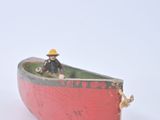 a small red boat with a man sitting in it