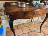 a wooden table with a glass of wine on it