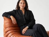 a woman sitting on a leather chair in a black shirt
