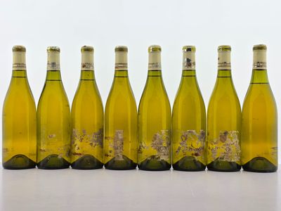 six bouteilles de vin blanc alignées sur une table