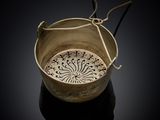 a close up of a bowl with a handle on a black surface