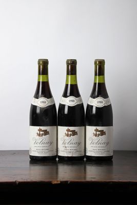 three bottles of wine sitting on top of a wooden table