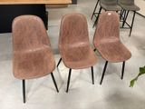 trois fauteuils en cuir marron placés dans une pièce où se trouvent une table et des chaises