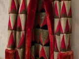 une photo d'un manteau rouge et beige accroché au mur