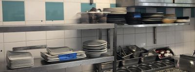 beaucoup d'assiettes et de casseroles sur les étagères de la cuisine
