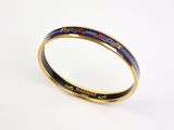 un gros plan sur un bracelet rigide en émail doré et bleu