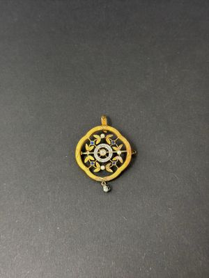 a close up of a yellow and black pendant on a black surface