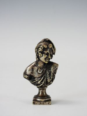 un buste en bronze représentant un homme coiffé d'un chapeau