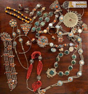 a wooden table topped with lots of assorted jewelry on top of it