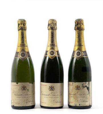 trois bouteilles de champagne posées les unes à côté des autres sur une surface blanche
