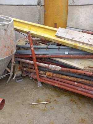 a pile of pipes and a cement mixer in a room