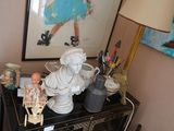 une petite table sur laquelle se trouvent une statue de femme et une poupée