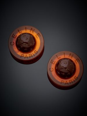 paire de deux boutons orange et noirs sur lesquels est représenté le visage d'un homme