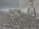Des bouteilles et des verres sont alignés sur une table à côté d'une carafe à vin.