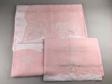 deux draps roses ornés de broderies blanches et d'un ruban blanc