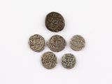 several silver coins are arranged in a circle on a white surface