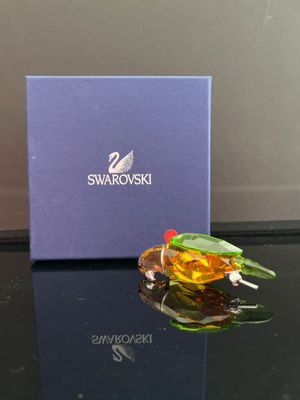 une figurine en verre représentant un oiseau posé sur une table