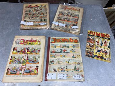 several comics are sitting on a table in front of a bunch of books
