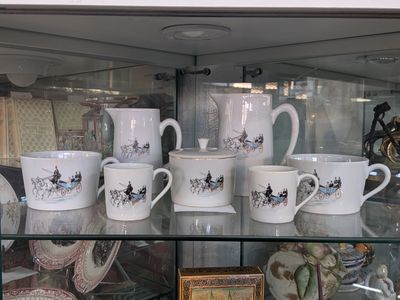 many cups and mugs on display in a glass case