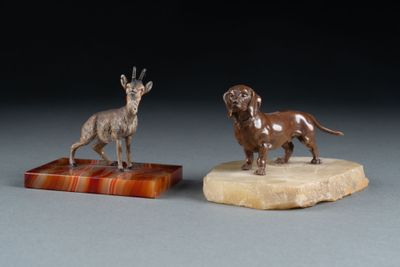 pair of bronze figurines of a dog and a goat on a marble base