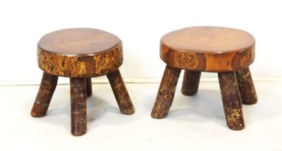 pair of small wooden stools with wooden legs on a white surface