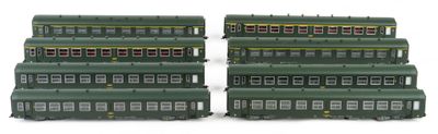 two green trains sitting side by side on a white surface