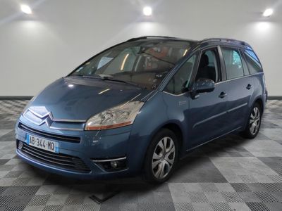 La petite voiture bleue est garée dans le garage, sur le sol à damier.