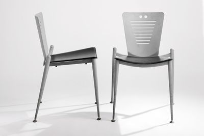 two chairs sitting next to each other on a white surface
