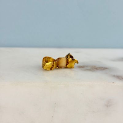 boucles d'oreilles à clous plaquées or posées sur une surface en marbre blanc