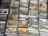 some old postcards are on a black table with a white sticker