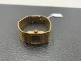 a close up of a gold watch on a black surface